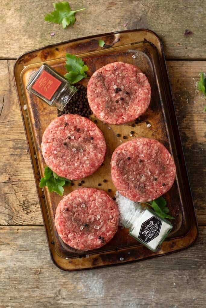 que carne tiene una hamburguesa - raw meat on brown wooden chopping board